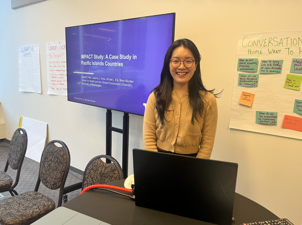 Woman smiling in front of a slideshow presentation
